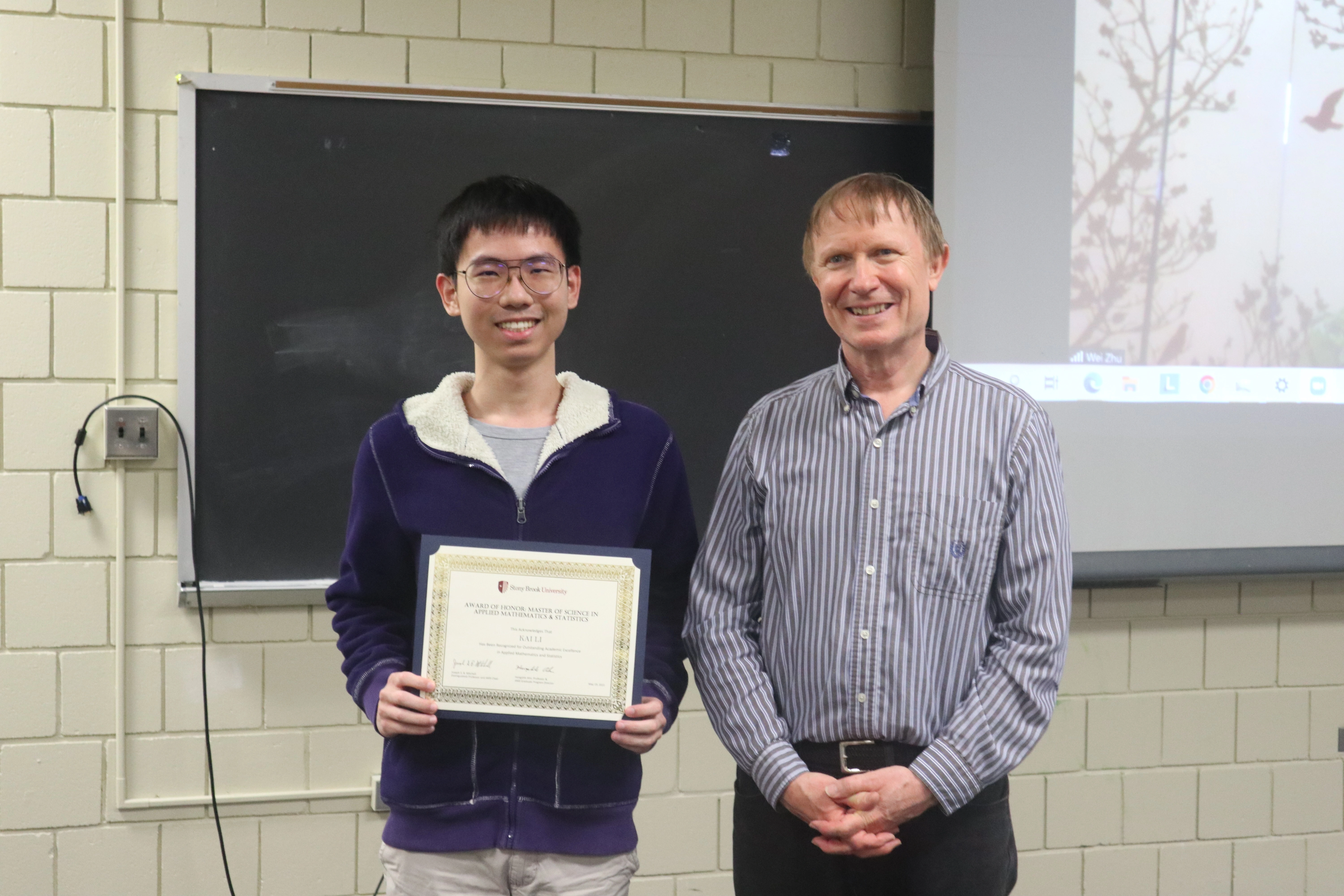 Kai Li holding an Applied Mathematics and Statistics award beside Professor Joseph Mitchell at Stony Brook University.